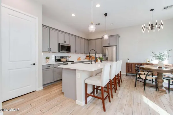 a kitchen with a dining table chairs stainless steel appliances and cabinets