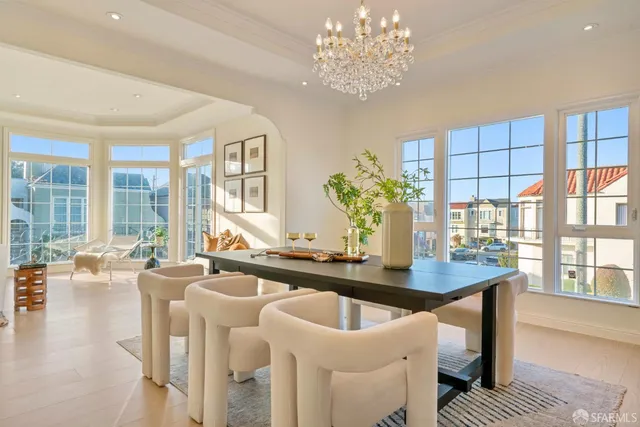 a dining room with furniture a chandelier and wooden floor
