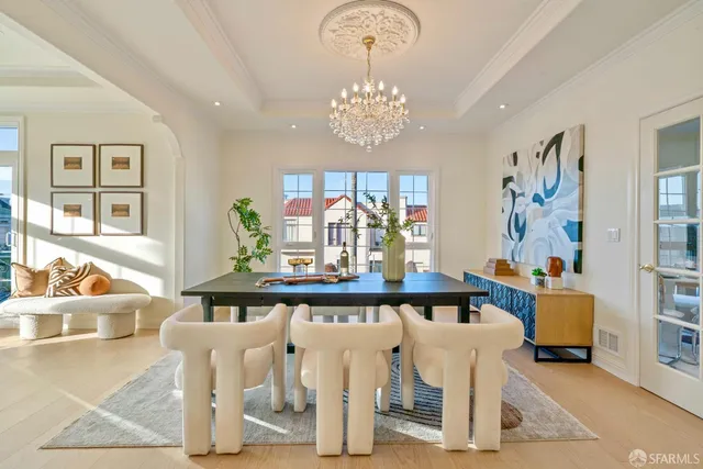 a view of a dining room with furniture a chandelier and a window