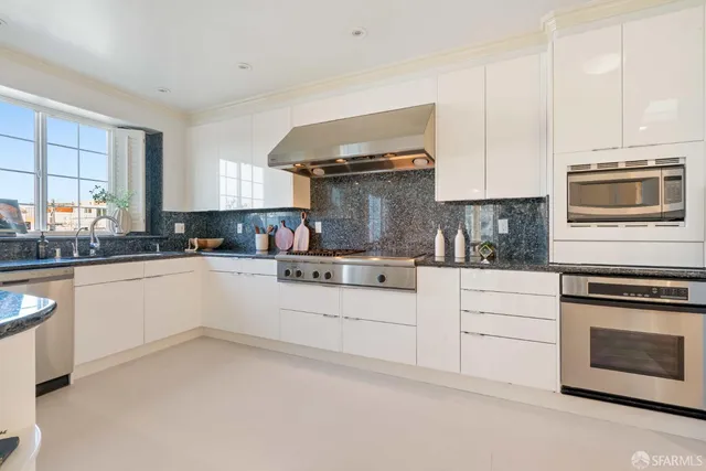 a living room with stainless steel appliances kitchen island granite countertop furniture and a large window