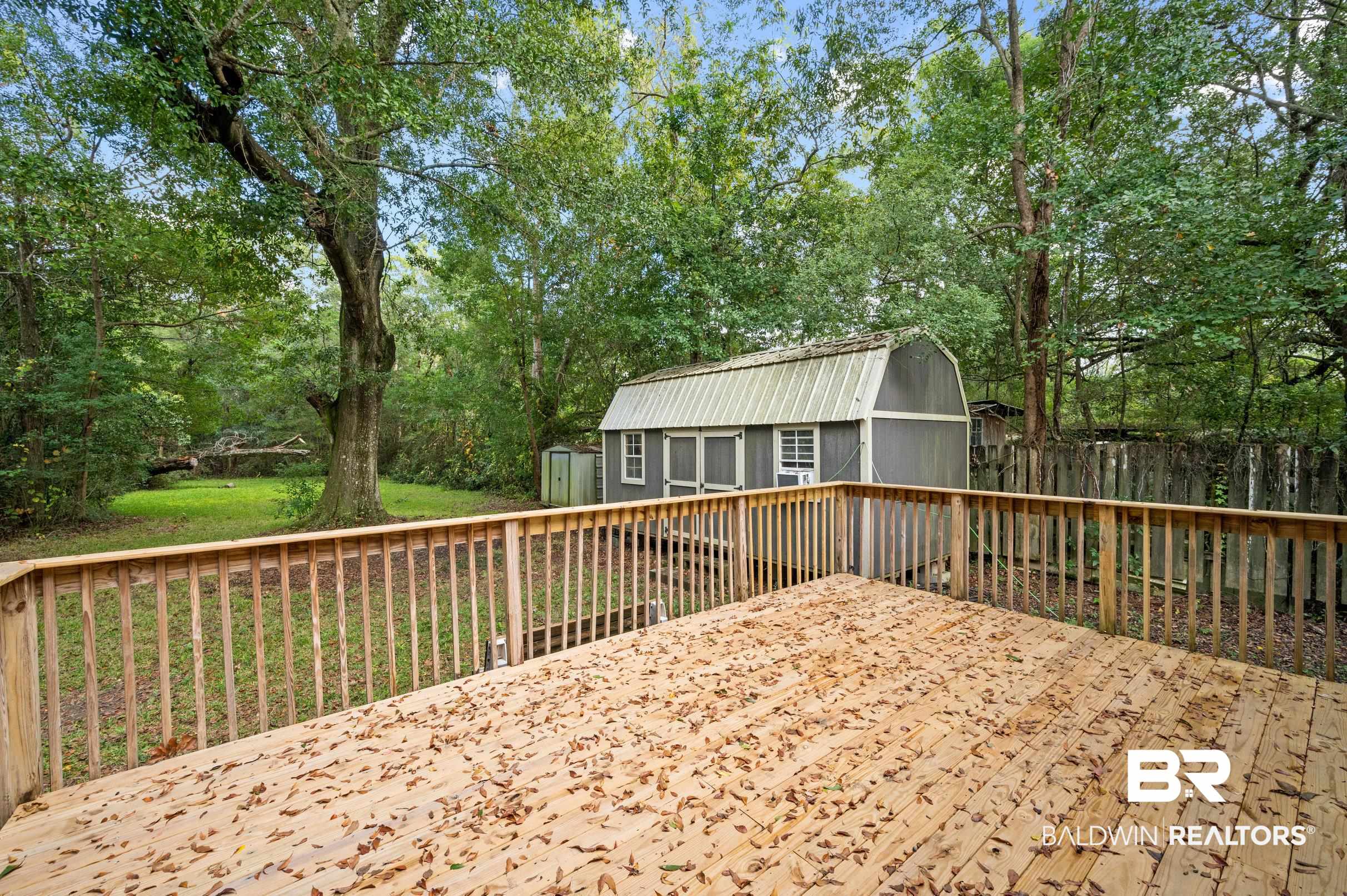 906 North Cedar Street Foley, AL 36535 - Photo 21 of 24 Wooden deck featuring a shed and a yard