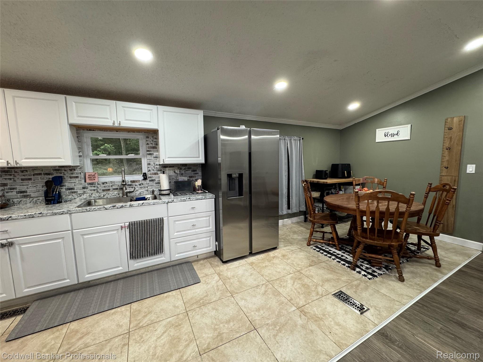 5323 English Road Clifford, MI 48727 - Photo 7 of 46 White cabinetry, stainless steel side-by-side refrigerator, tile flooring, stone finish backsplash, and recessed lighting