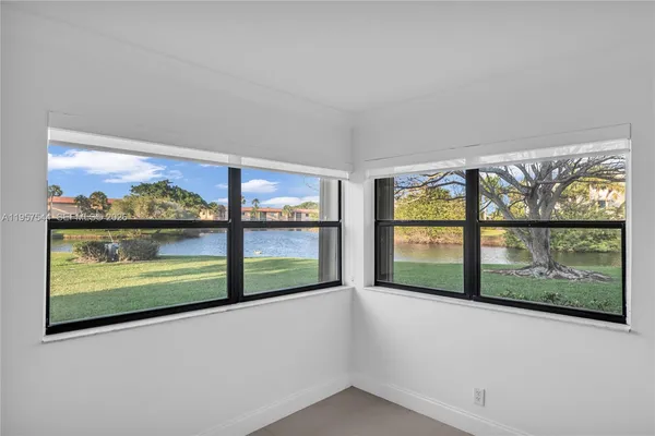 a view of backyard with large trees and wooden fence