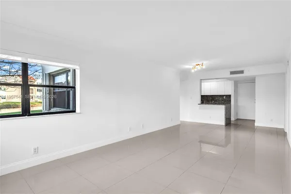 an empty room with windows and cabinet