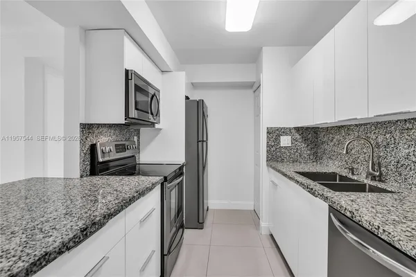 a kitchen with granite countertop a sink and stainless steel appliances
