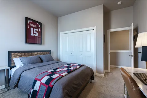 a bedroom with a bed and painting on the wall