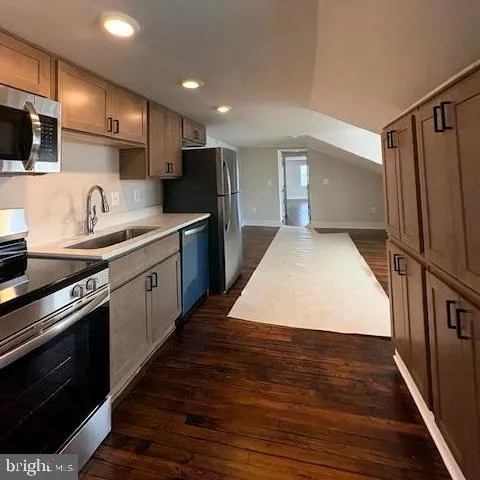 a large kitchen with stainless steel appliances granite countertop a sink a stove and a refrigerator