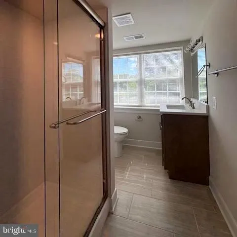 a spacious bathroom with a granite countertop sink toilet and shower