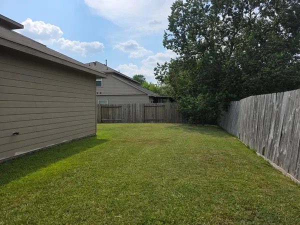 a view of a backyard with a small cabin and wooden fence