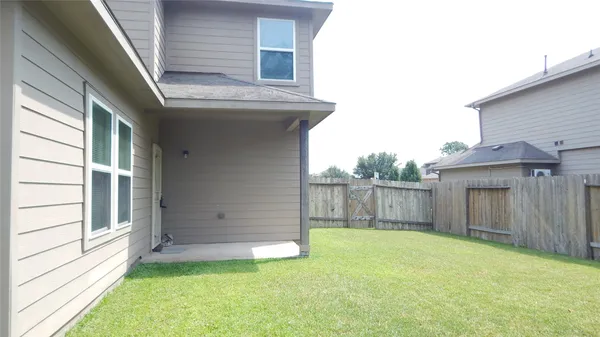 a view of a backyard with wooden fence