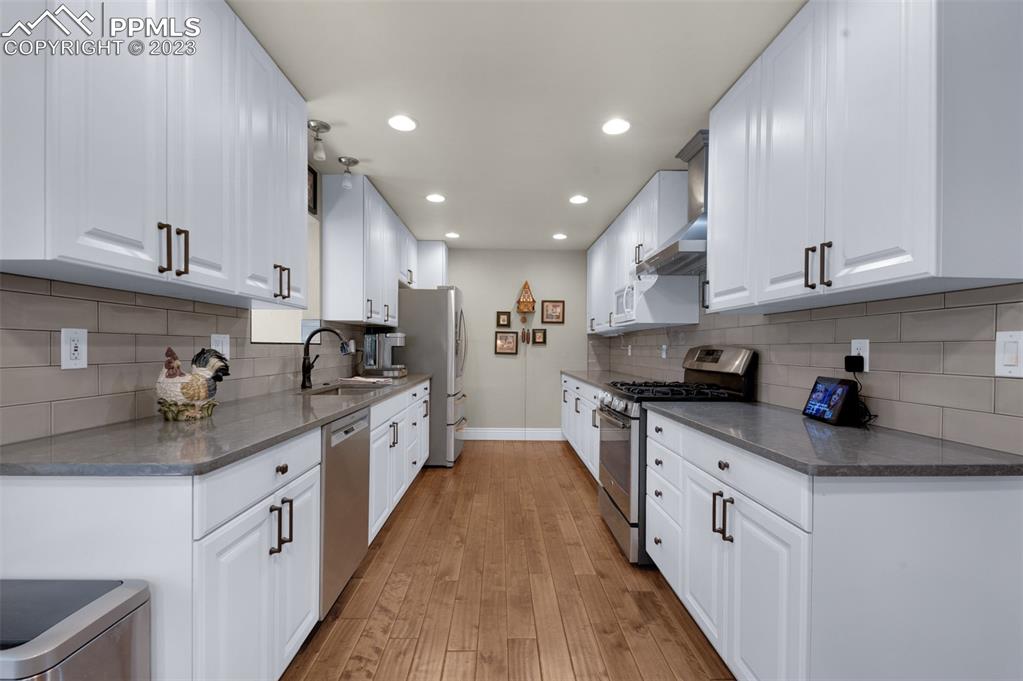 16635 High Tree Drive Elbert, CO 80106 - Photo 16 of 50 a kitchen with granite countertop kitchen island stainless steel appliances a sink a stove top oven and white cabinets