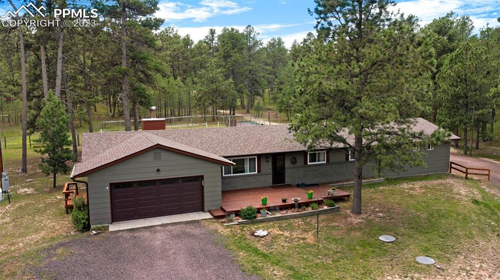 16635 High Tree Drive Elbert, CO 80106 - Photo 2 of 50 a view of a house with a yard garage and a chair under an umbrella