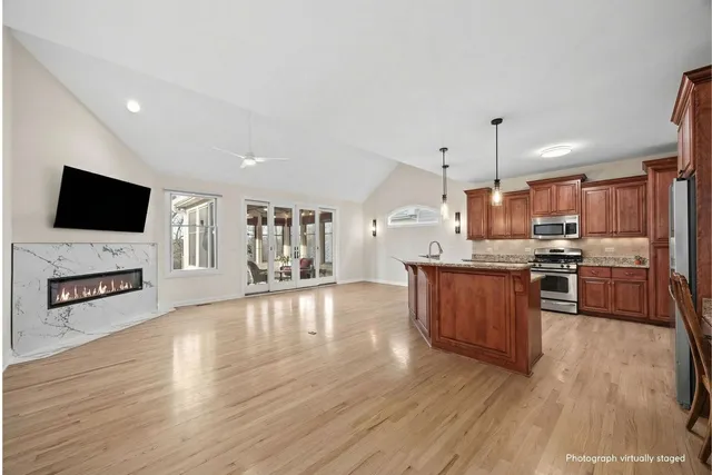 a large kitchen with stainless steel appliances wooden floors and wooden cabinets