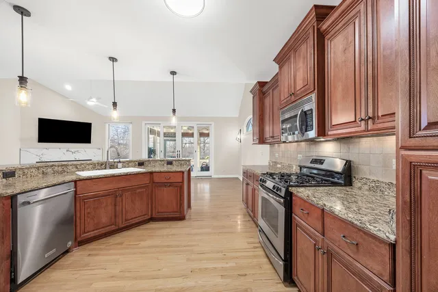 a kitchen with stainless steel appliances granite countertop a stove sink and cabinets