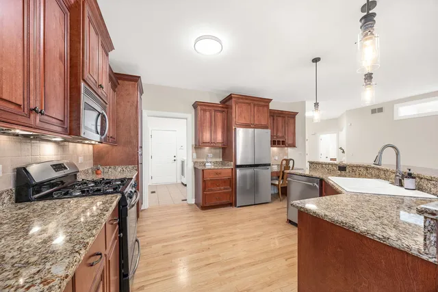 a kitchen with stainless steel appliances granite countertop a sink stove and refrigerator