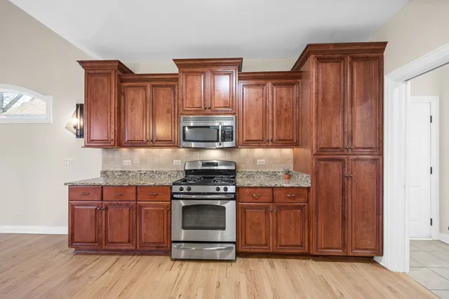 a kitchen with wooden floors and wooden cabinets