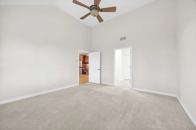 an empty room with closet and ceiling fan
