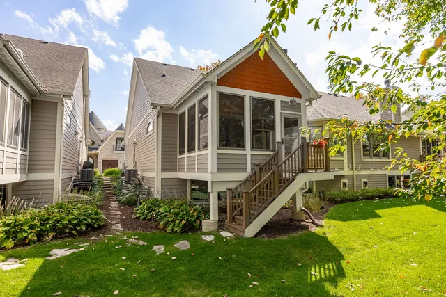 a front view of a house with a yard and potted plants
