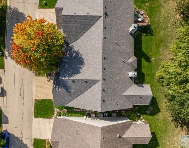 an aerial view of ocean and residential houses with outdoor space
