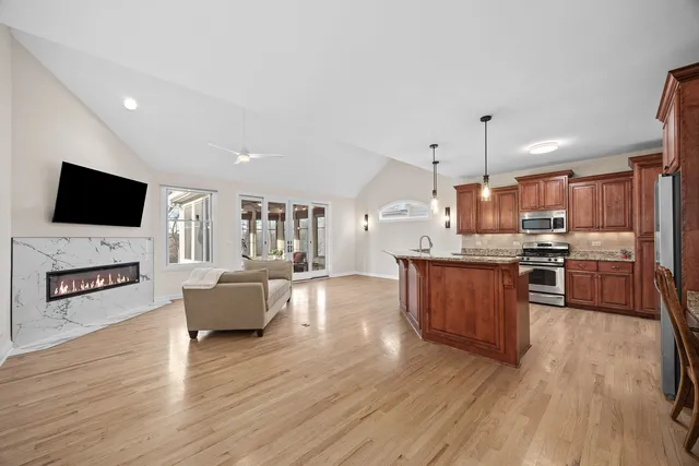 a large living room with stainless steel appliances granite countertop a couch and a view of living room