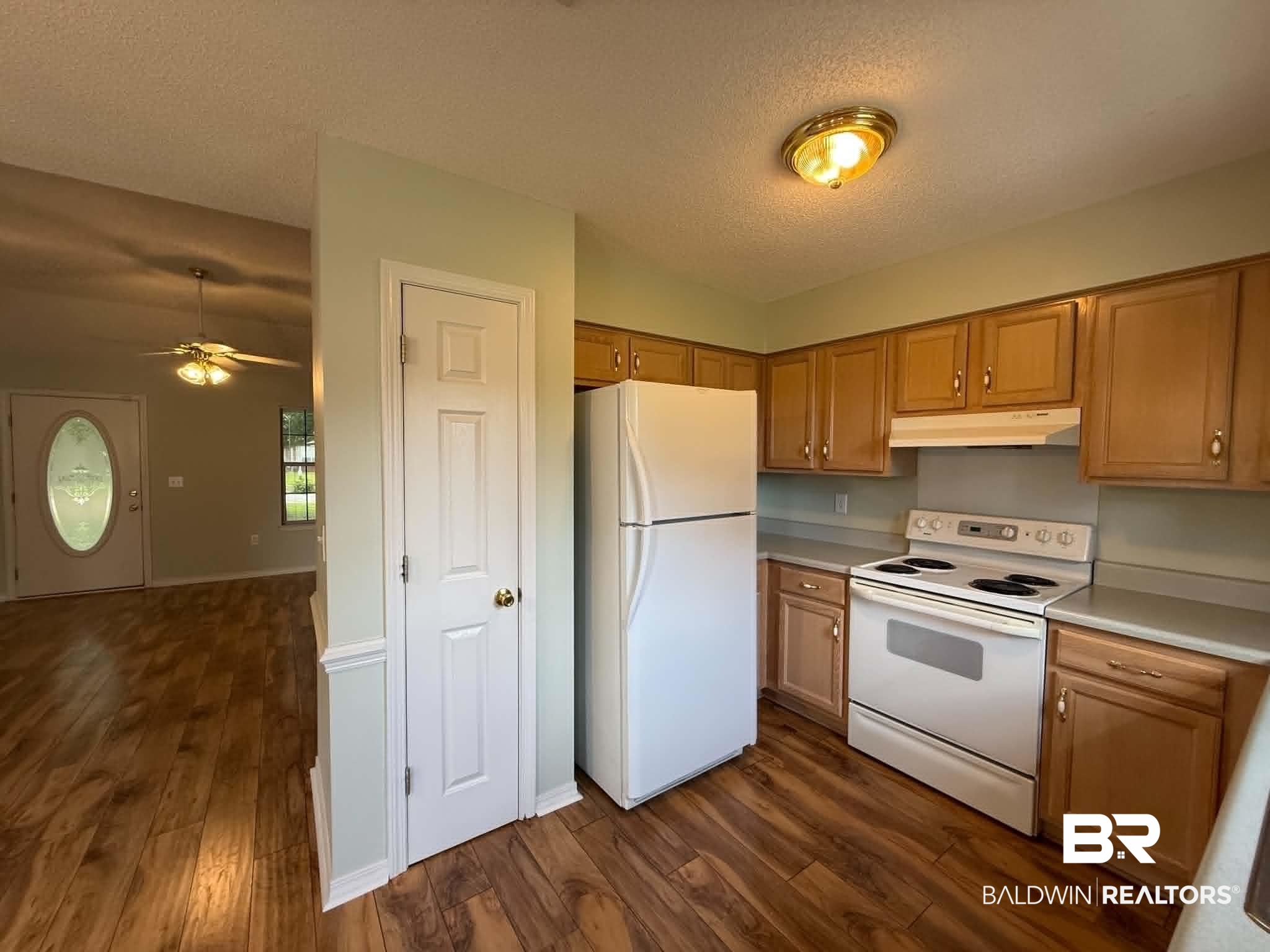 123 Pennbrooke Loop Foley, AL 36535 - Photo 24 of 49 Kitchen featuring wood-finish flooring, light wood cabinetry, white appliances, and a built-in pantry