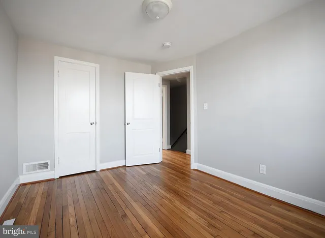 a view of an empty room with wooden floor