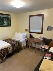 a bedroom with bed couch and window