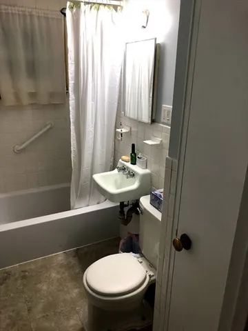 a bathroom with a sink a toilet a mirror and bathtub