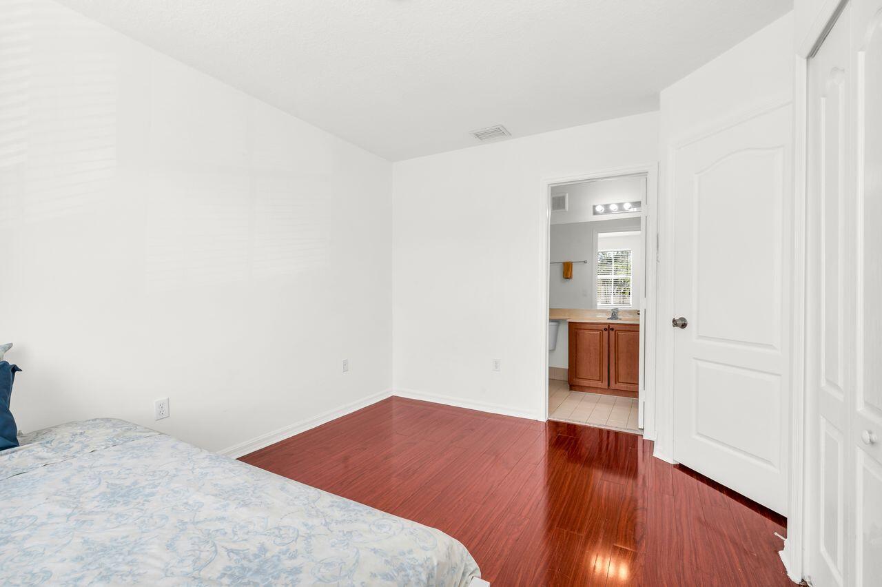 3169 Southwest 129th Terrace, Unit 164 Miramar, FL 33027 - Photo 12 of 20 a bedroom with a bed and wooden floor