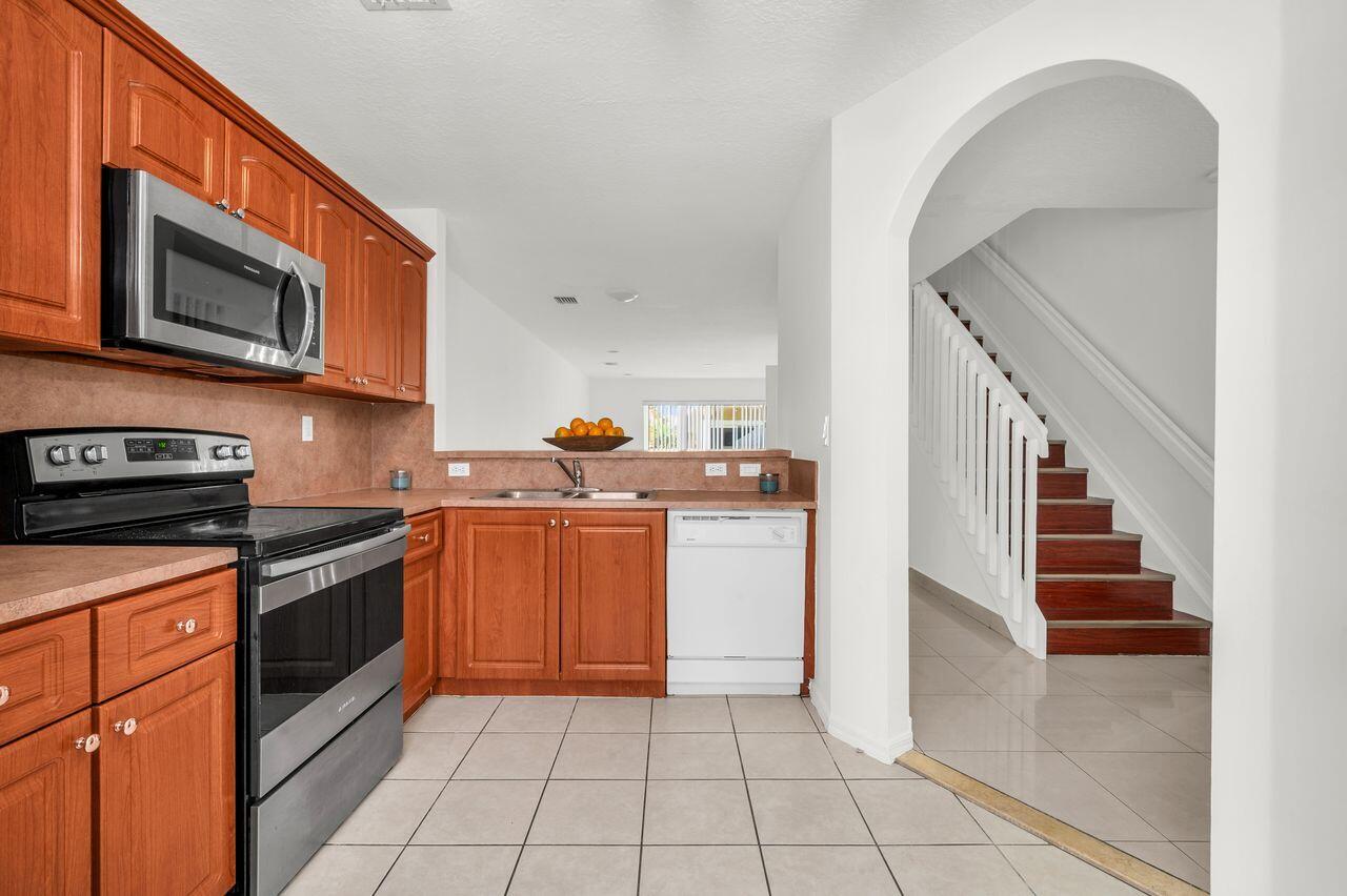 3169 Southwest 129th Terrace, Unit 164 Miramar, FL 33027 - Photo 5 of 20 a kitchen with stainless steel appliances granite countertop a stove a microwave and a sink