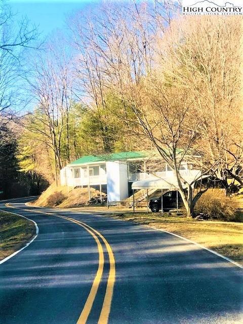 786 Teaberry Road Warrensville, NC 28693 - Photo 2 of 35 a front view of a house with garden and trees