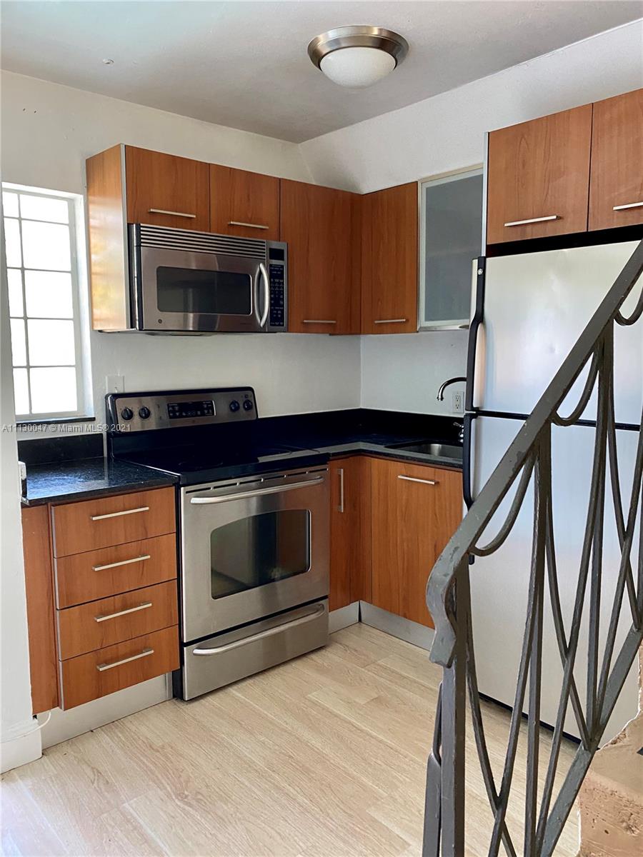 a kitchen with stainless steel appliances kitchen island a stove a sink and a microwave