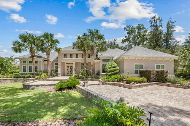 a front view of a house with a yard and potted plants