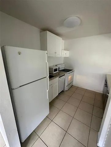 a kitchen with cabinets and white stainless steel appliances