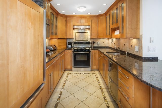 a kitchen with granite countertop a sink stainless steel appliances and cabinets