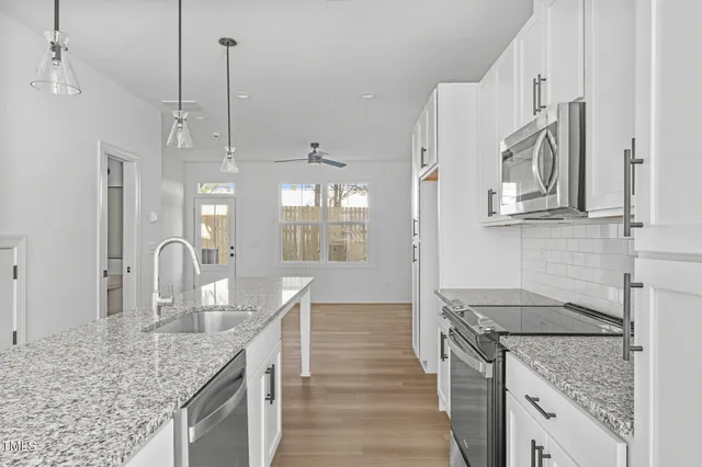 a kitchen with stainless steel appliances granite countertop a sink stove and refrigerator