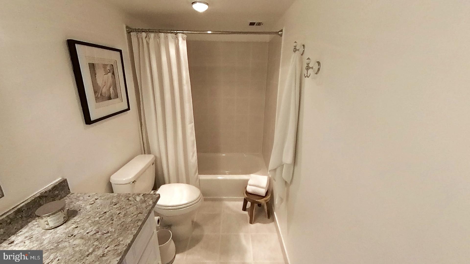 1915 Benning Road Northeast Washington, DC 20002 - Photo 6 of 22 a bathroom with a granite countertop toilet a sink and a mirror