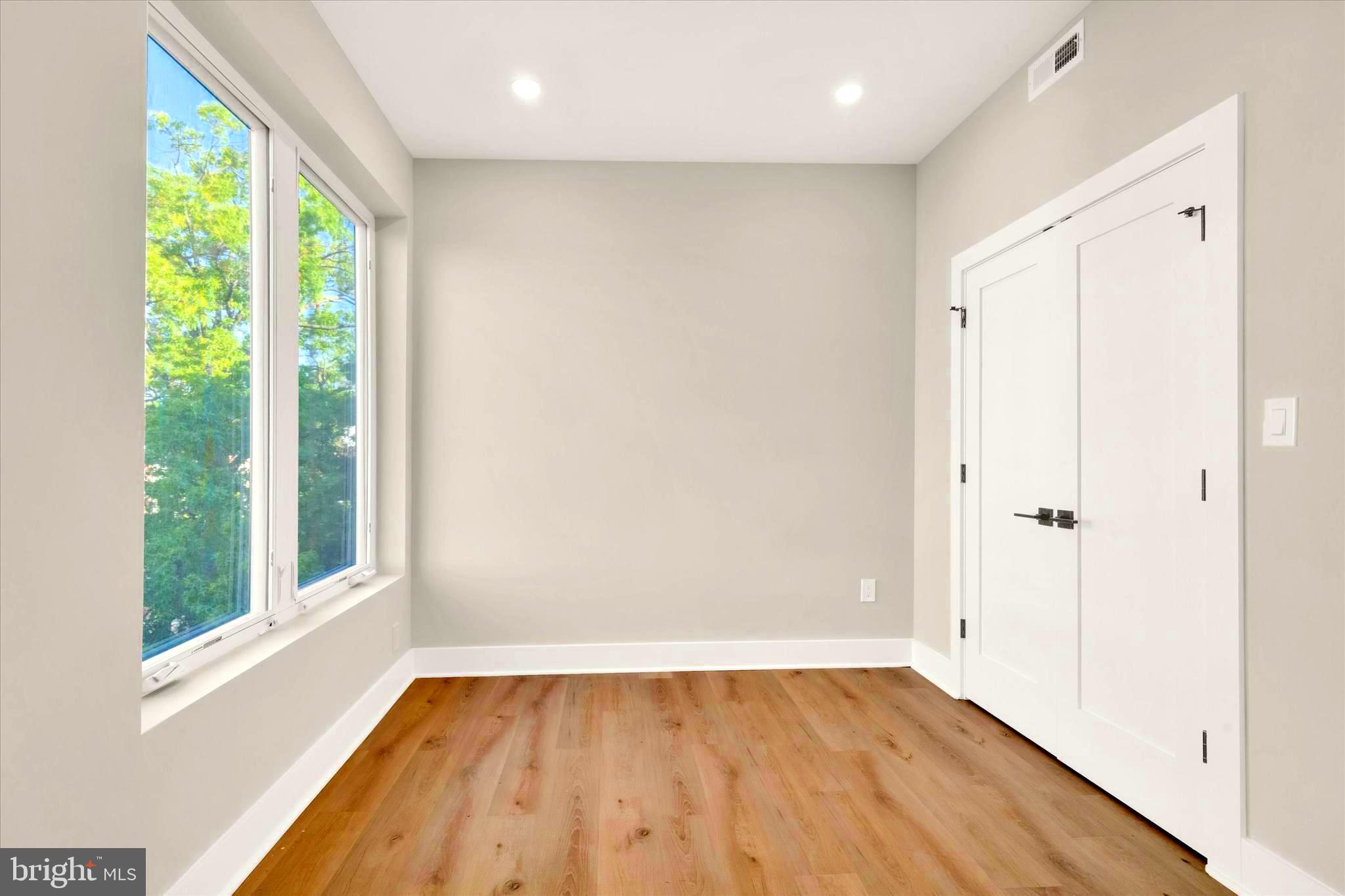 1915 Benning Road Northeast Washington, DC 20002 - Photo 7 of 22 a view of an empty room with wooden floor and a window