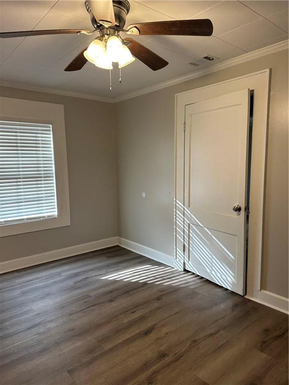 615 Cassville Road Southeast Cartersville, GA 30120 - Photo 12 of 24 an empty room with wooden floor chandelier fan and windows
