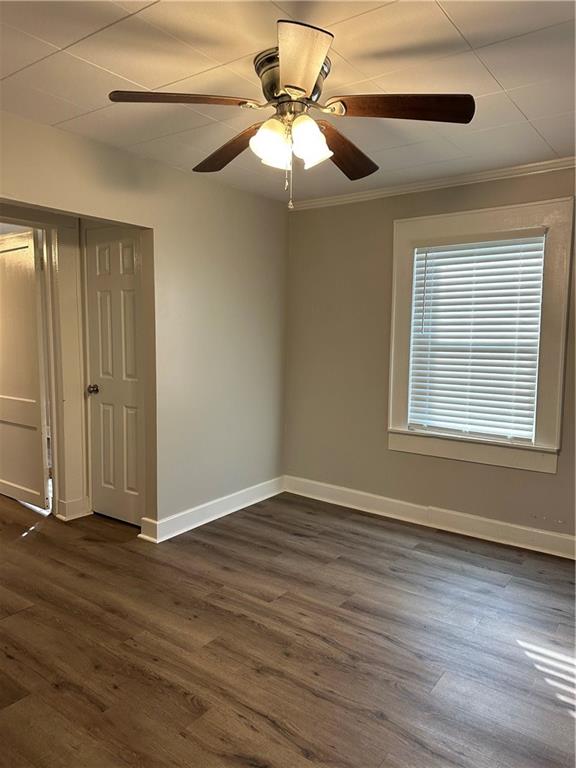615 Cassville Road Southeast Cartersville, GA 30120 - Photo 13 of 24 an empty room with wooden floor chandelier fan and windows