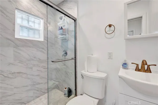 a bathroom with a shower a toilet and a sink