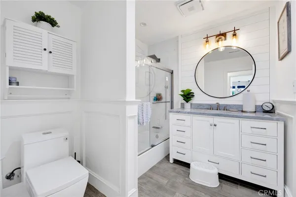 a bathroom with a granite countertop toilet sink and mirror