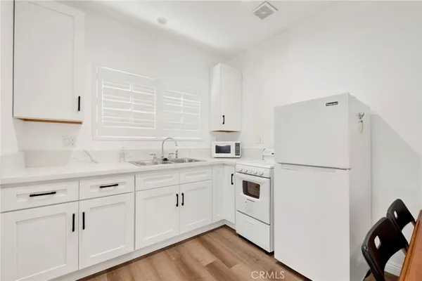 a kitchen with white cabinets and white appliances