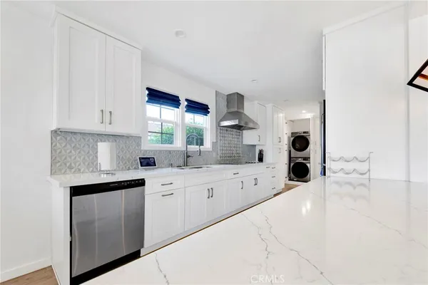 a large white kitchen with a sink and cabinets