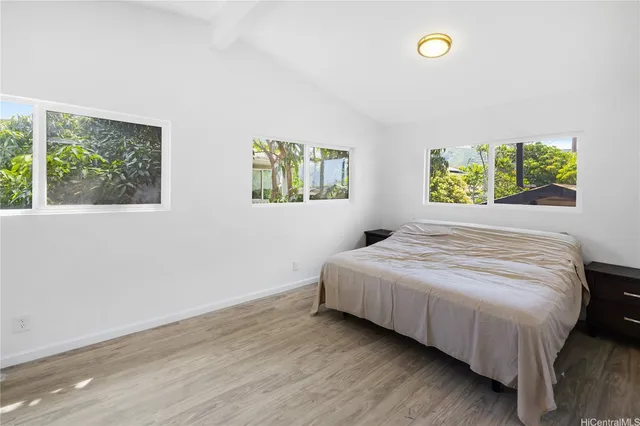 a bedroom with a bed and two windows