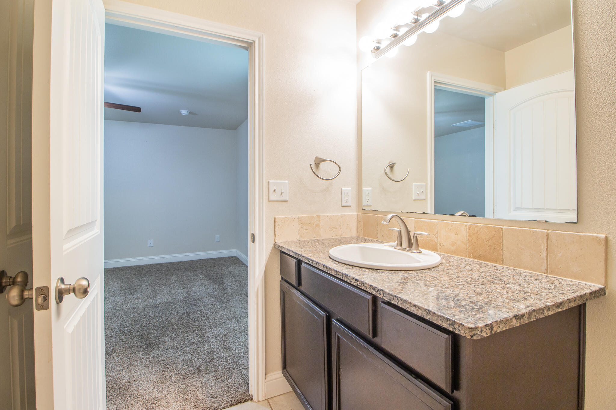 7409 101st Street Lubbock, TX 79424 - Photo 13 of 22 a bathroom with a granite countertop sink and a mirror