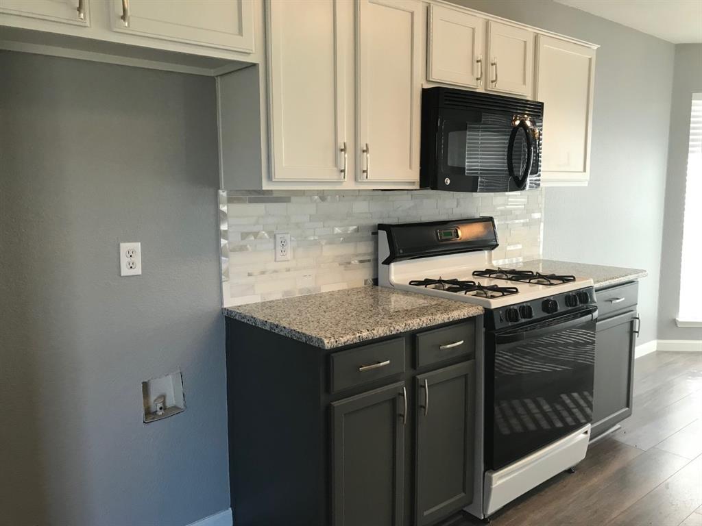 3305 Rustic Meadow Trail Mansfield, TX 76063 - Photo 5 of 12 Modern kitchen featuring two-tone cabinetry with white upper and charcoal lower cabinets, granite countertops, and a subway tile backsplash