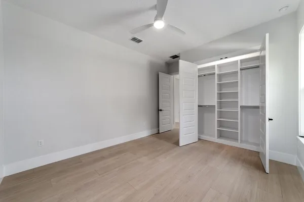 a view of a hallway with wooden floor and windows
