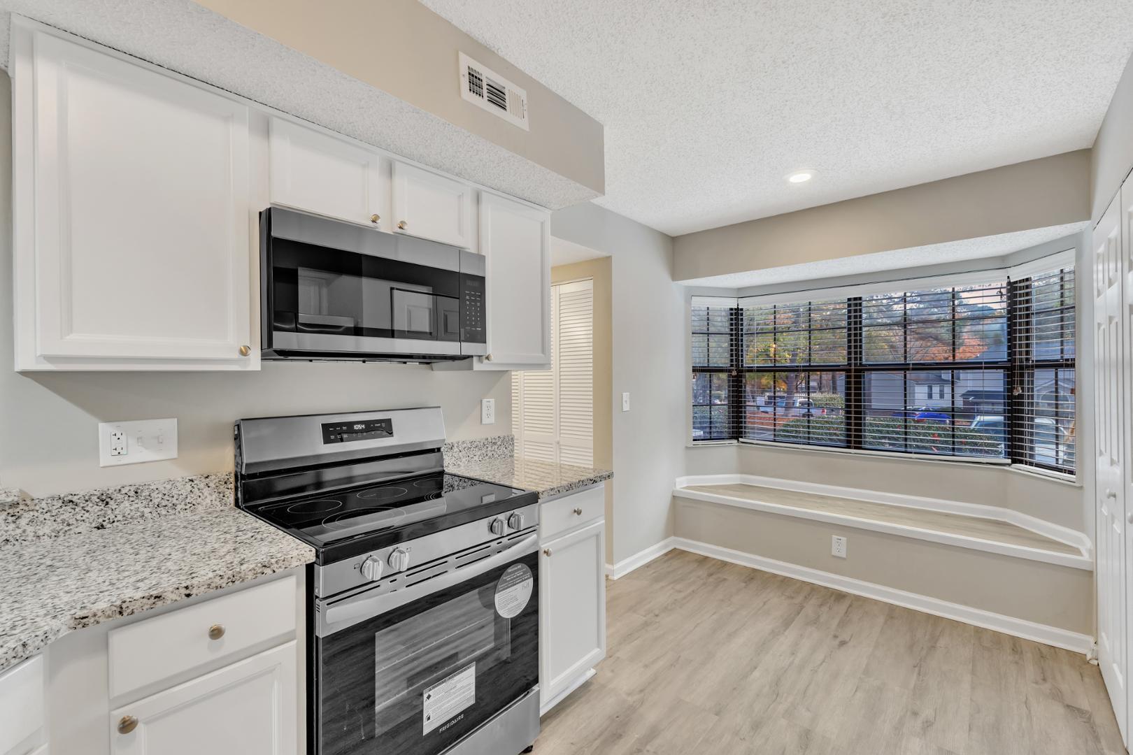 2430 Condor Court Raleigh, NC 27615 - Photo 12 of 34 a kitchen with stainless steel appliances granite countertop a stove and a microwave