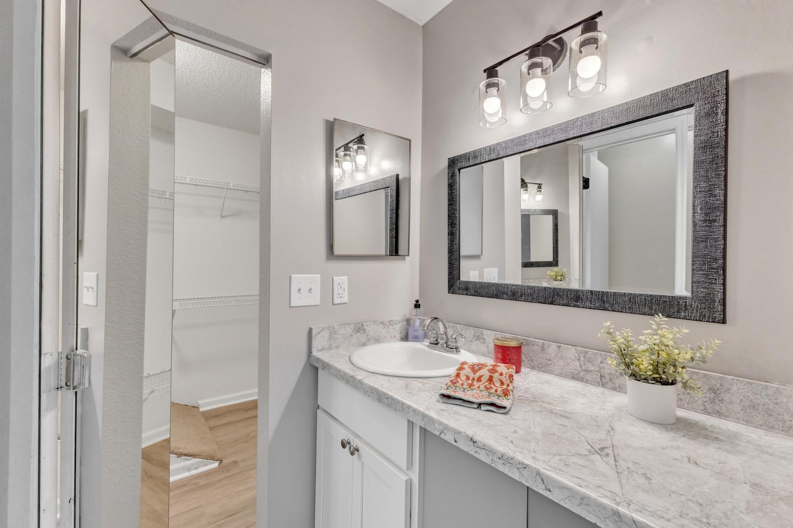 2430 Condor Court Raleigh, NC 27615 - Photo 20 of 34 a bathroom with a granite countertop sink a large mirror a and shower
